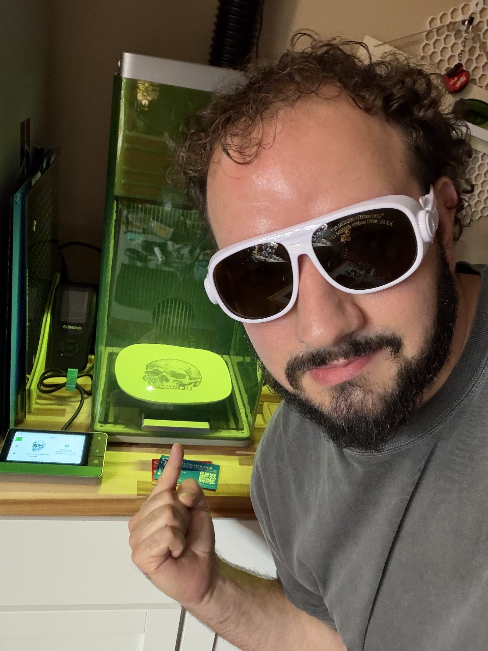 Steve Holder wearing safety glasses beside his laser engraver